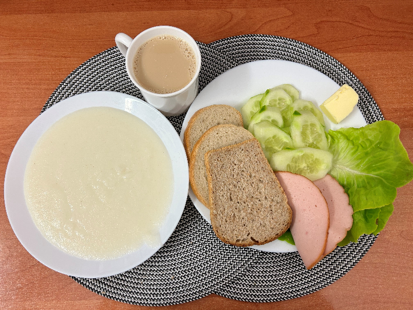 Na zdjęciu: Kasza manna na mleku, Kawa zbożowa z mlekiem, Chleb mieszany pszenno-żytni, Chleb Graham, Masło extra 82%, Filet zapiekany drobiowy, Ogórek świeży, Sałata zielona